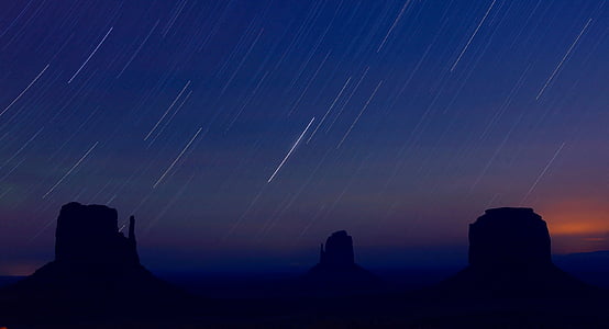 silhouette photo of stone mountain with falling stars thumbnail