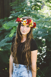 woman wearing red and yellow flower headband and black shirt standing near green leaf tree during daytime thumbnail