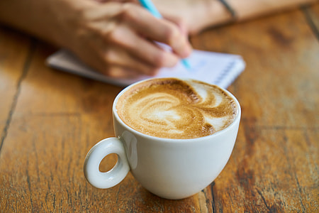 cappuccino filled cup on brown table thumbnail