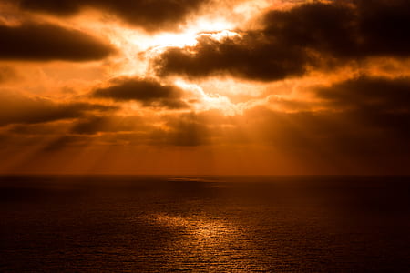 sunlight behind clouds over the sea thumbnail