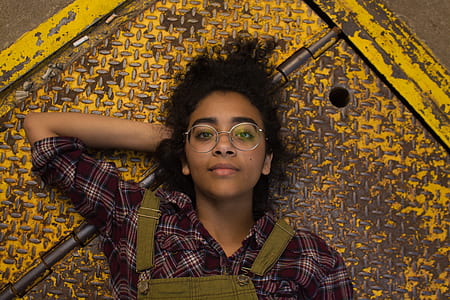 girl with curly hair lying down on yellow metal trapdoor thumbnail