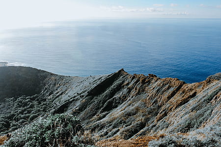 aerial photo of gray mountain with view of body of water thumbnail