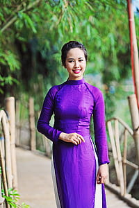 woman in purple mandarin collared long-sleeved dress posing under trees thumbnail