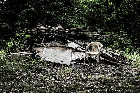 monobloc chair beside pile of woods thumbnail
