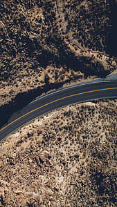 curve black asphalted road near valley with cactus during daytime thumbnail