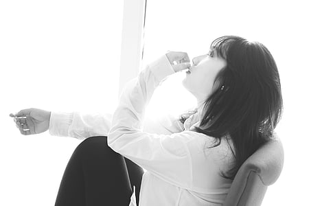 grayscale photo of woman sitting on chair thumbnail