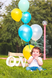 Girl Wearing White Shirt Near Teal, White, and Yellow Ballons thumbnail