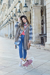 candid photography of woman standing holding leashed chihuahua dog thumbnail