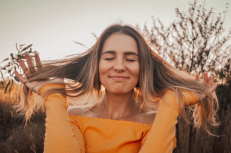 woman closing eyes while holding her hair thumbnail