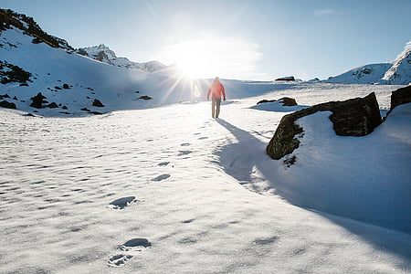 person walking on snow field at daytime thumbnail