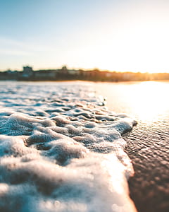 close-up photography of ocean wave on shore overlooking sunset thumbnail