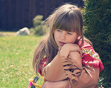 girl wearing Native American costume behind tree thumbnail