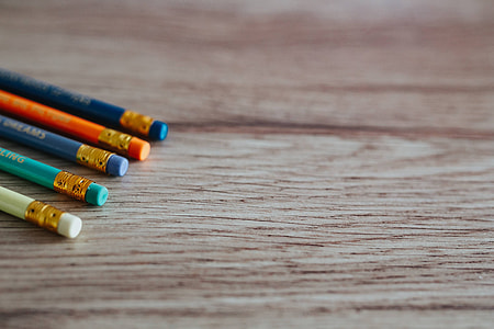 Notebooks with colourful pencils on a wooden desk thumbnail