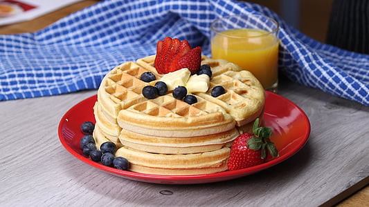 piled waffle on plate beside glass thumbnail