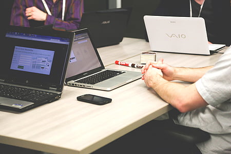 people sitting beside table with laptop computers thumbnail