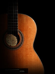 photography of brown classical guitar in dark background thumbnail