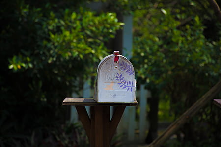 white mail box on brown stand thumbnail