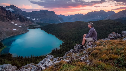man on sitting on rock cliff photography thumbnail