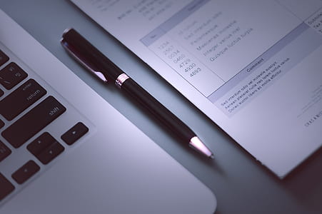 two black twist pen near laptop thumbnail
