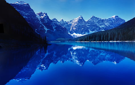 lake near brown mountain under blue sky during daytime thumbnail