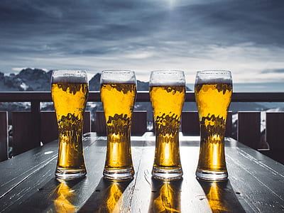 four beer mugs on table and mountain at distance thumbnail