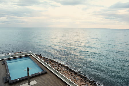 high angle view of swimming pool beside body of water thumbnail
