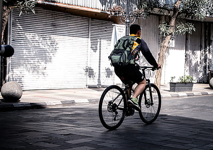 man cycling on road at daytime thumbnail