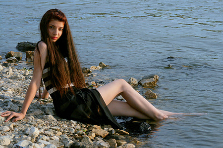 woman wearing black dress sitting on shore thumbnail