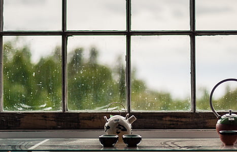 white ceramic teapot with two cups infront of the window thumbnail