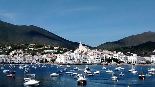 white concrete buildings near body of water with boats thumbnail