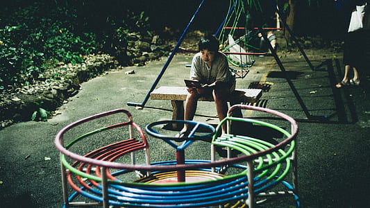 person wearing gray top looking on round multicolored play park thumbnail