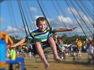 boy riding on swing during daytime thumbnail