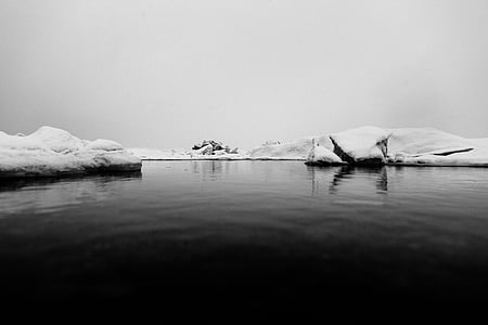dark calm water surrounded by ice thumbnail