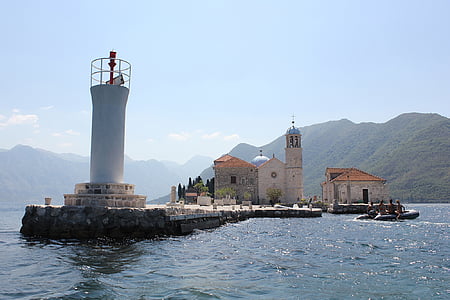 gray and brown concrete houses and tower near body of water thumbnail