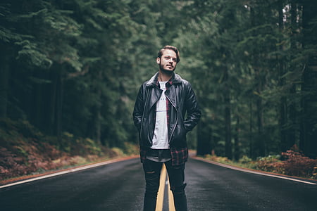 man wearing black leather jacket in the middle of road thumbnail