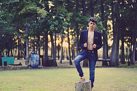 man standing with right foot on tree stump thumbnail