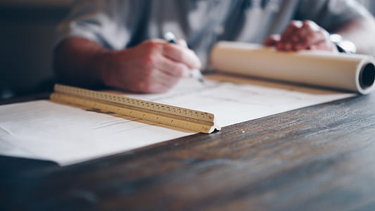 person drawing on paper using pen and ruler thumbnail