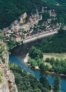 aerial photography of river beside village surrounded by green mountain thumbnail