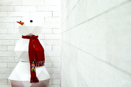 Snowman near wall during daytime thumbnail