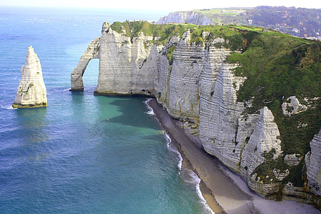 white rock formation with green leafed plants thumbnail