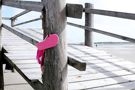 pink flip-flop hanging on dock thumbnail