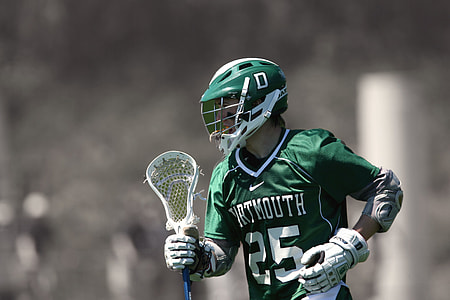 selective focus photo of man holding lacrosse stick thumbnail