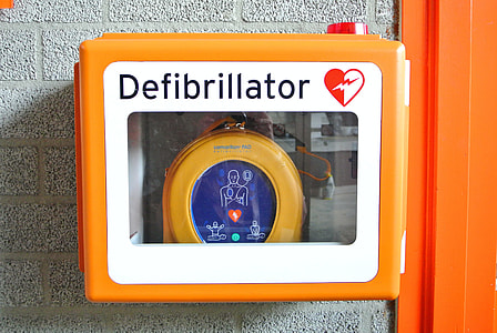 orange and white defibrillator on wall thumbnail