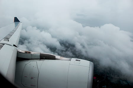 white plane's right wing above thick white clouds view from plane window thumbnail