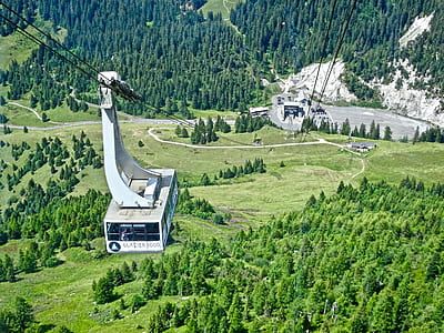 white cable car above green trees thumbnail