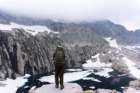 man with backpack front of mountain thumbnail