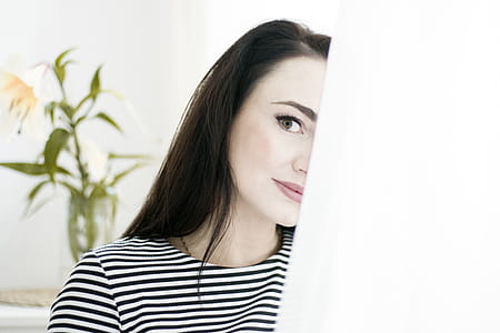 Woman in White and Black Striped Top Near Leafed Plant thumbnail