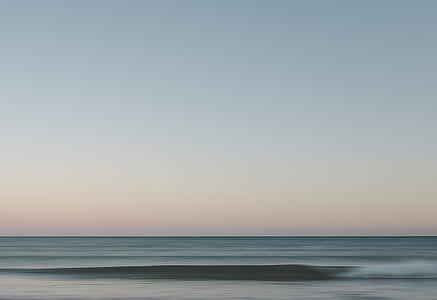 body of water under clear blue sky thumbnail