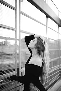 grayscale photo of woman holding hair beside grill thumbnail