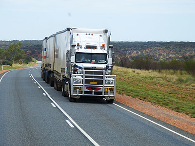 white cargo truck on concrete road under blue sky during daytime thumbnail